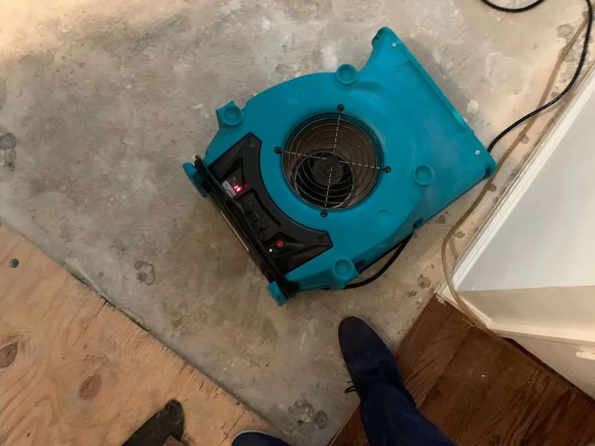 Air mover drying subfloor during Commercial Water Damage Restoration in Greeley